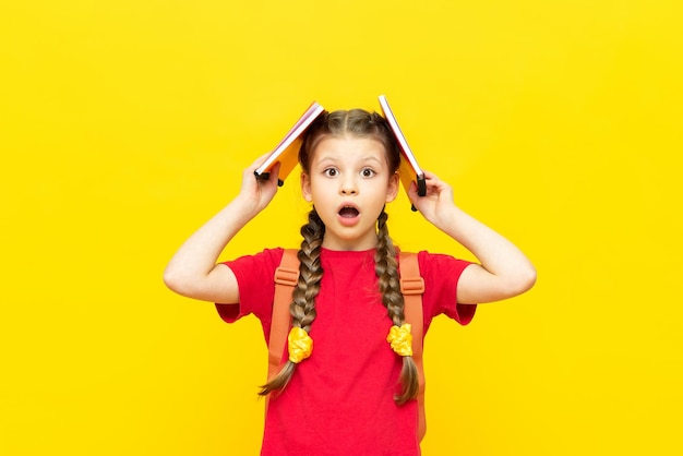 A schoolgirl with a satchel is getting ready to go to school Children's education Preparatory courses for schoolchildren Additional classes for successful exams Yellow isolated background