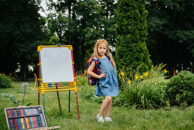 A schoolgirl writes lessons on a blackboard and is engaged in outdoor training