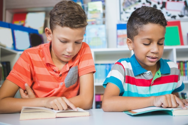 Schoolkids reading book in library