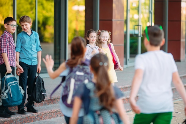 Photo schoolmates go to school. students greet each other.