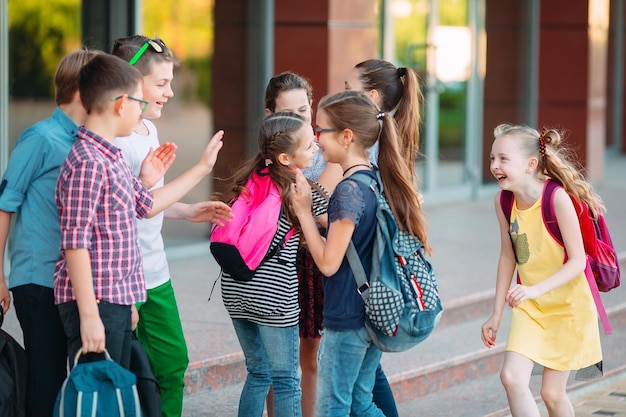 Schoolmates go to school. Students greet each other.