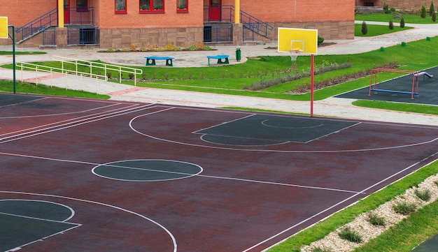 Schoolyard with a playground for basketball. Doing sports at school