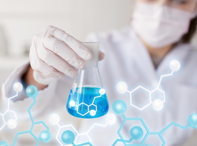 science, chemistry, biology, medicine and people concept - close up of young female scientist with flask making test or research in clinical laboratory