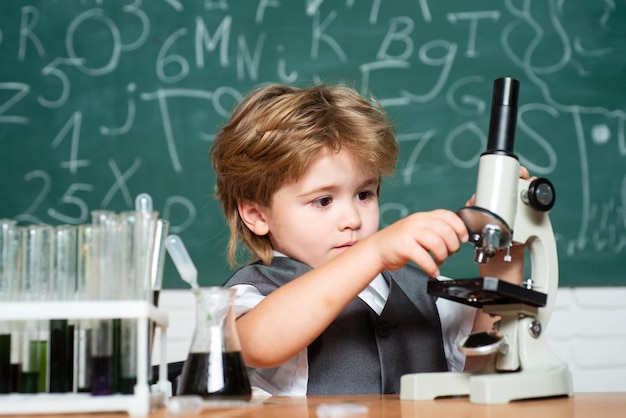 Science and education concept Chemistry science Elementary school schoolboy Cheerful smiling little boy having fun against blue wall