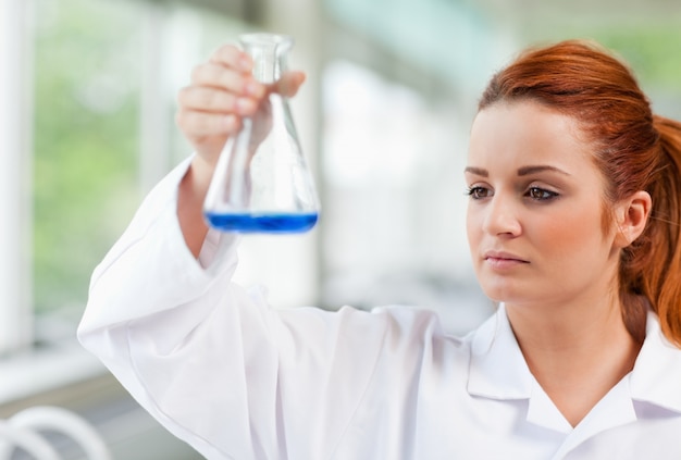 Science student looking at a blue liquid