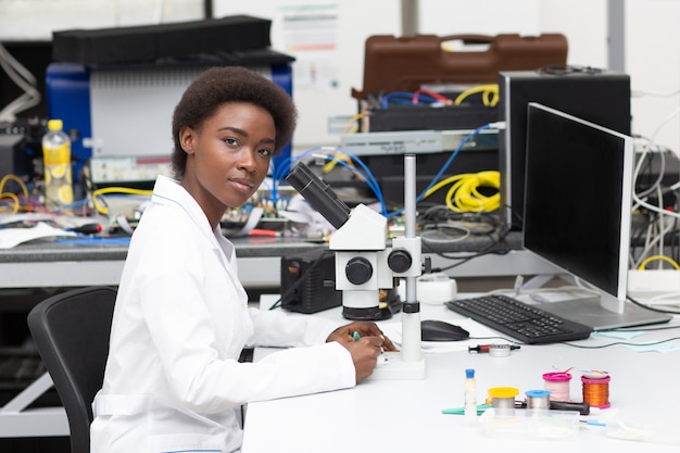 scientist african american woman engineer in laboratory with microscope