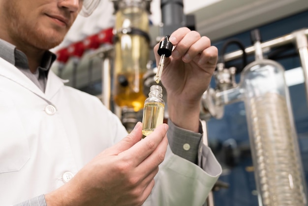 Scientist or apothecary extract CBD hemp oil for medicinal purpose in laboratory