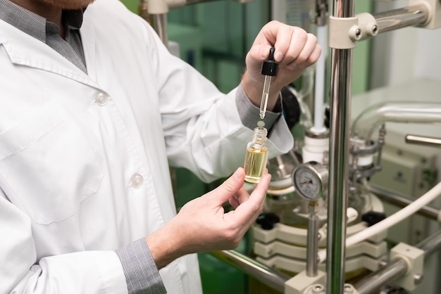 Scientist or apothecary extract CBD hemp oil for medicinal purpose in laboratory