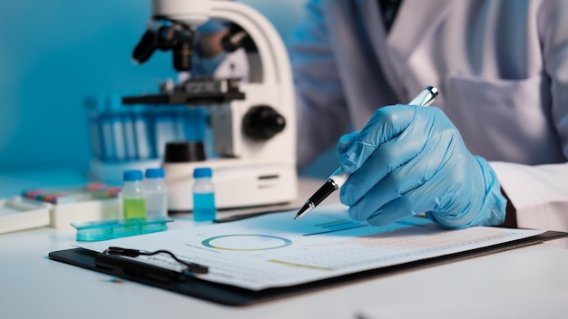 Photo scientist hand taking a sample tube from a rack with machines of analysis in the lab background technician holding tube test in the research laboratory