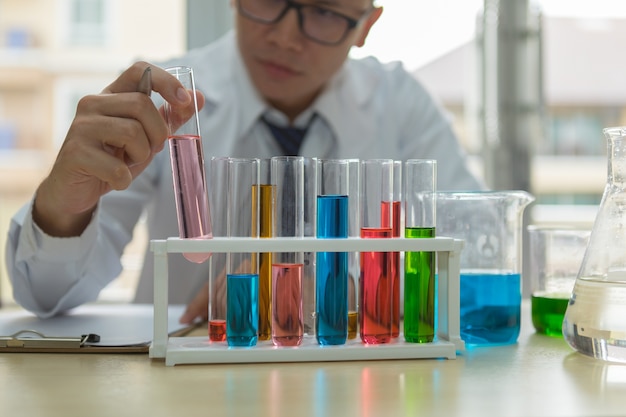 Scientist hold and see test tube of glass for examine the chemical results in chemical man