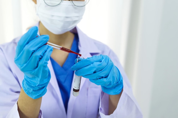 Scientist holding Coronavirus covid19 infected blood sample tube DNA testing of the blood in the laboratory with blood sample collection tubes and syringe Coronavirus Covid19 vaccine research