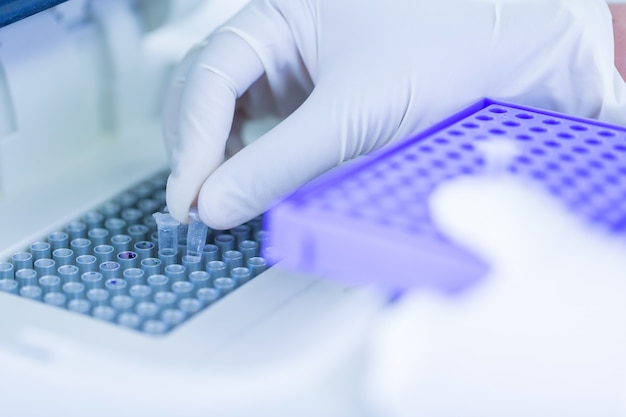 Scientist loading a sample to centrifuge in laboratory