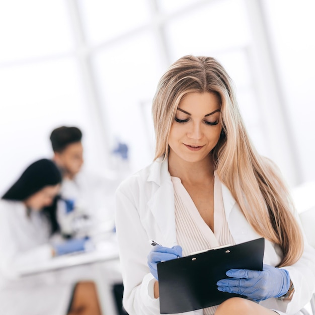 Scientist make notes to the clipboard in the clinical laborator