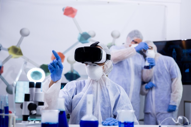 Scientist in modern research laboratory using virtual reality goggles. Modern equipment in lab.