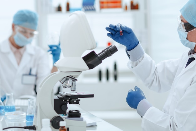 scientist opening an ampoule with a new vaccine 