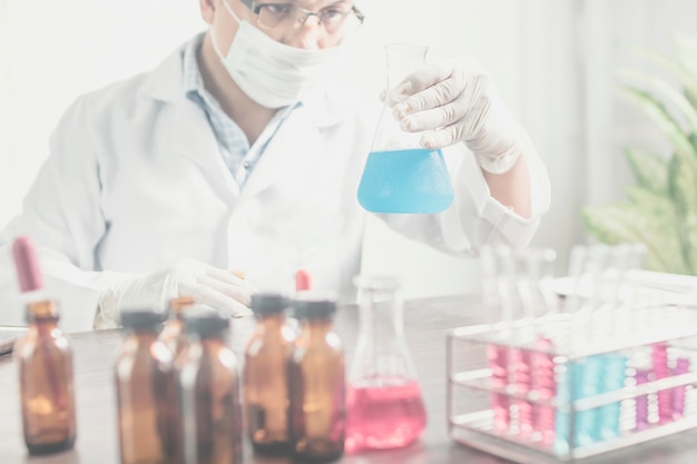 Scientist or researcher holding flask in science lab.