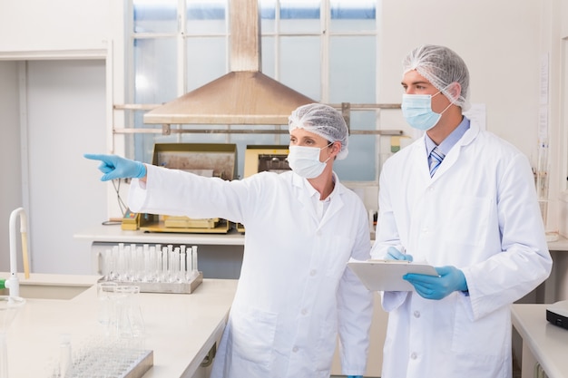 Scientist showing something to her colleague 