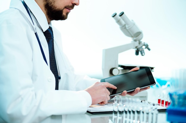 Scientist using a digital tablet in a science lab .