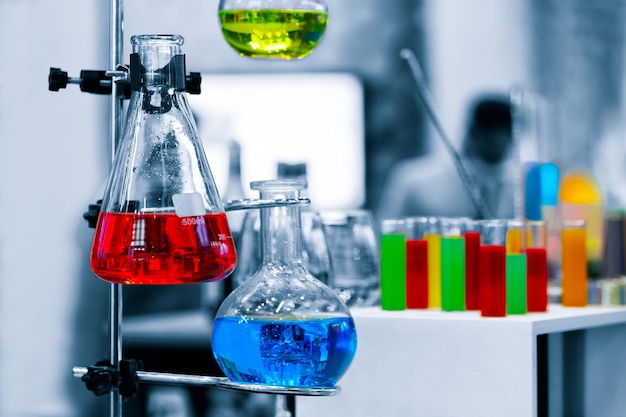 Scientist working with chemical reaction in chemistry laboratory. close up of scientist making research in lab, chemical molecular on blue chemistry science laboratory background