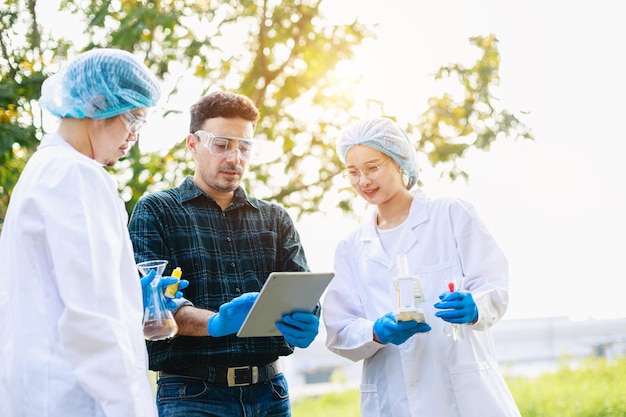 Scientists biologists analysis with digital tablet about Environment issues at industrial estate