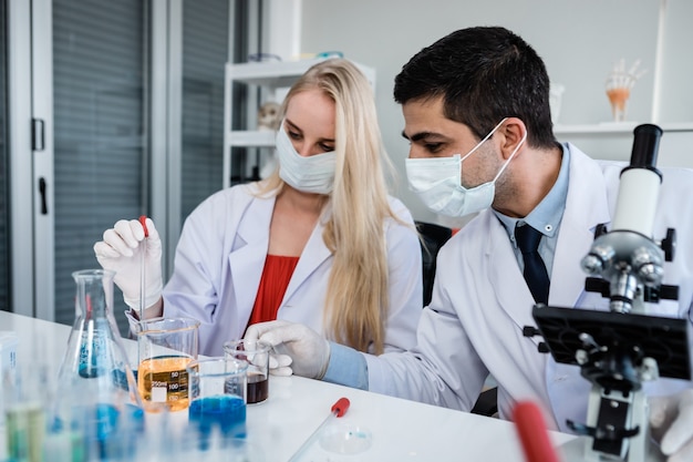 Scientists looking at test tube with sample in a chemistry lab scientist or young female