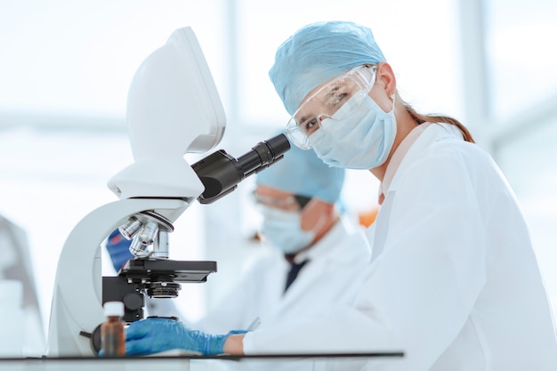 scientists testing the liquid and writing the results in a laboratory journal