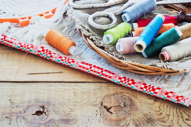 Scissors, bobbins with thread and needles, striped fabric. Old sewing tools