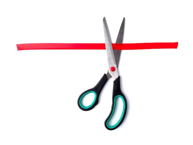 Scissors cutting red sticky tape on a white background View from above