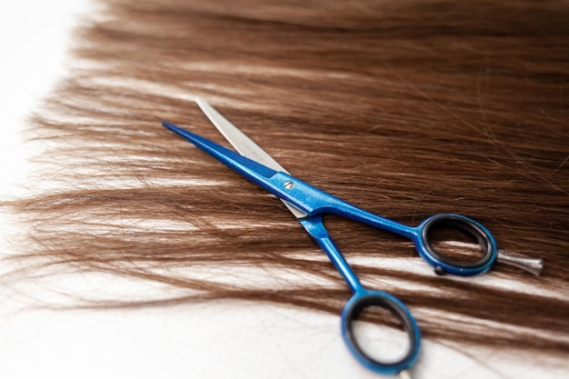 Scissors lie on the hair ribbon for extension at home. Hair extensions to thicken your own.