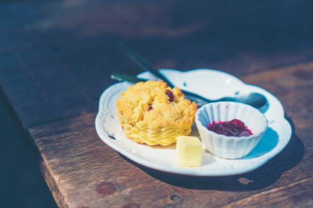 scones with clotted cream and jam, strawberries on the background