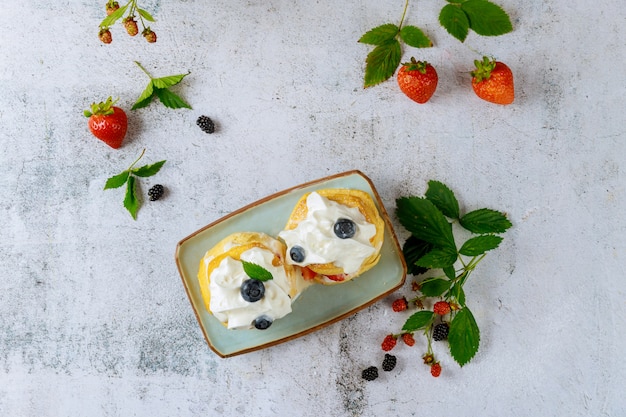 Scones with whipped cream and wild berry.