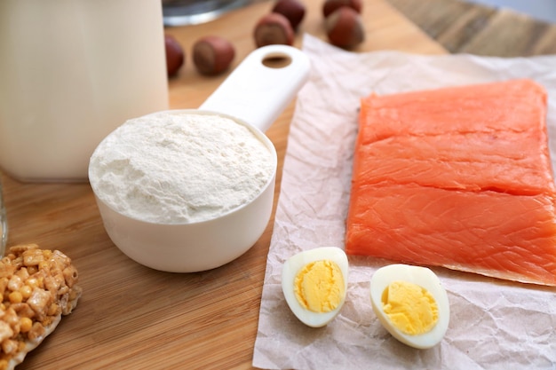 Scoop with protein powder and products on table