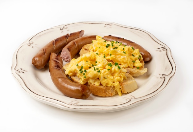 Scrambled eggs with sausages served on a plate