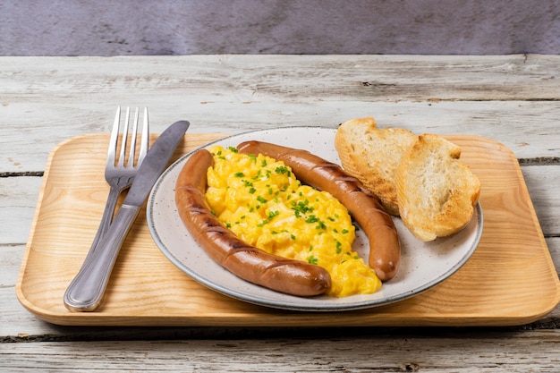 Scrambled eggs with sausages served on a plate