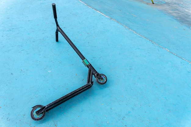 The scratched scooter lies after falling to the ground