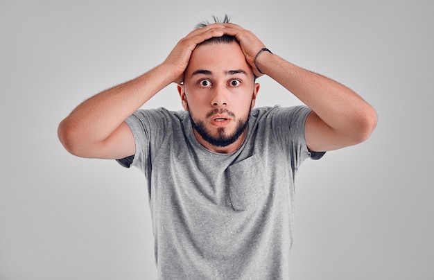 Screaming, hate, rage. Crying emotional angry man screaming on gray studio background. Emotional, young face. male half-length portrait. Human emotions, facial expression concept.