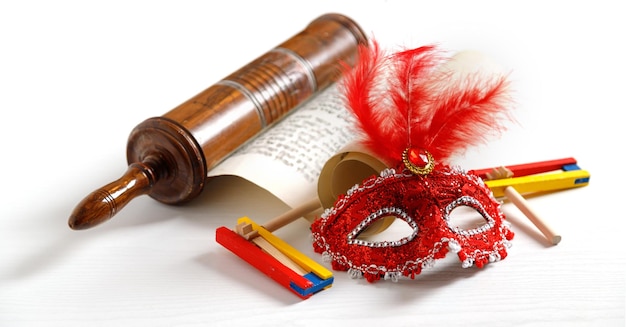 The Scroll of Esther and Purim Festival objects rattles masquerade mask on white background