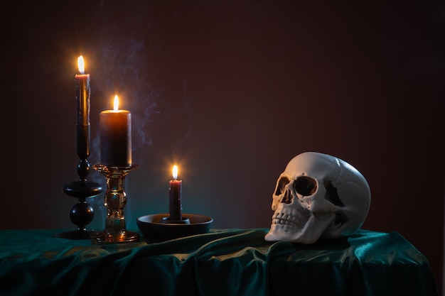 scull and burning candles with halloween decor on dark background