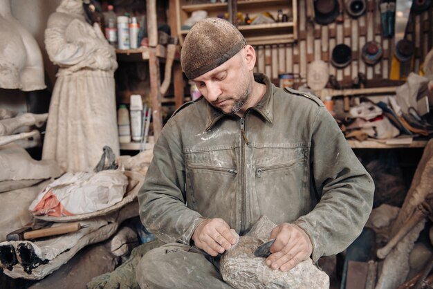 Sculptor man working in his workshop