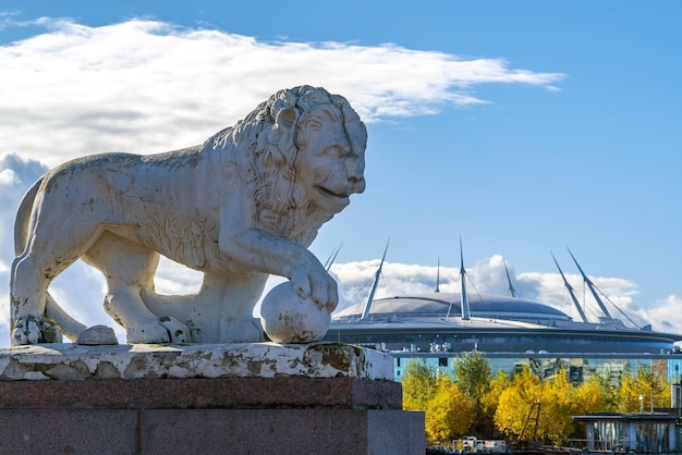 Sculpture of a lion with a ball on the background of the Zenit Arena building Elagin Island SaintPetersburg