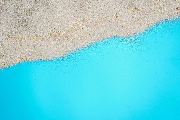 Sea beach sand texture on blue background with copy space Summer background