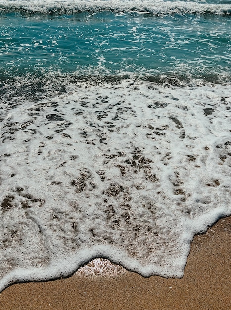 sea blue aquamarine waves line sunny sand beach. soft wave of ocean foam. natural background sky