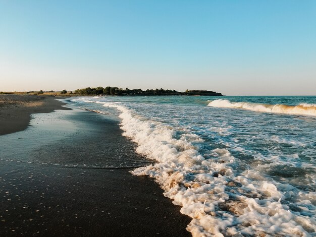 sea blue aquamarine waves line sunny sand beach. soft wave of ocean foam. natural background sky