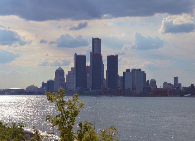 Photo sea by city buildings against sky