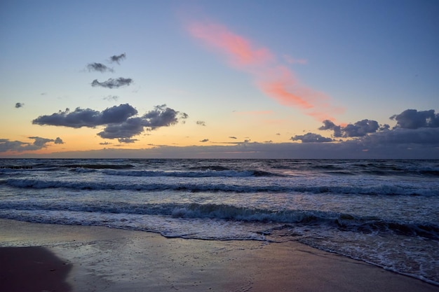 Sea coastline with waves baltic sea against dramatic cloudy sky at sunset panoramic nature landscape