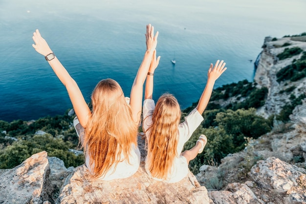 Sea family vacation together happy mom and teenage daughter hugging and smiling together over sunset