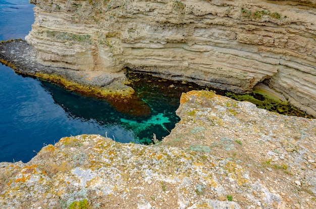 A sea grotto with clear water between the rocks.