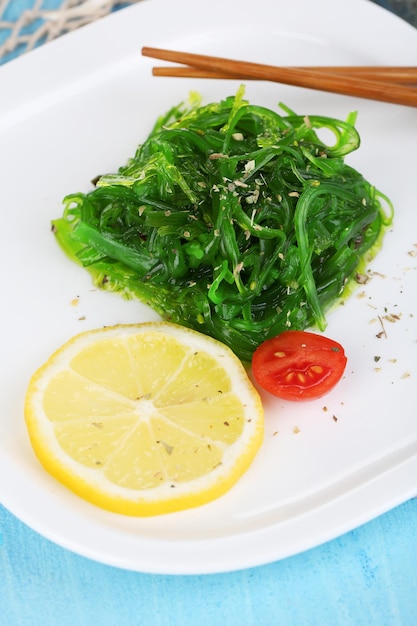 Sea kale on plate on wooden table closeup