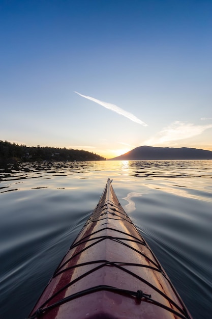 Sea kayak paddling in the pacific ocean colorful sunset sky