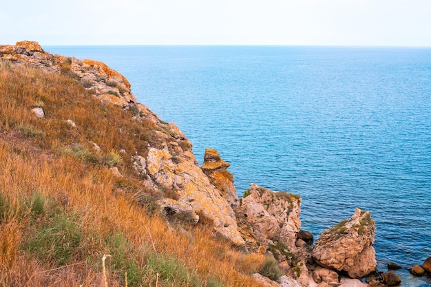 Sea mountain landscape Blue sea and rocks with dry grass Travel and tourism